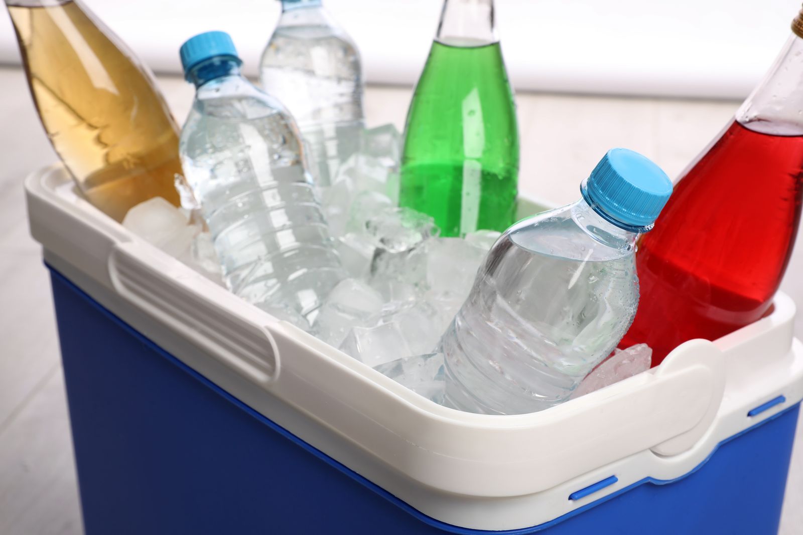 Cold drinks and water bottles packed in ice in a cooler box